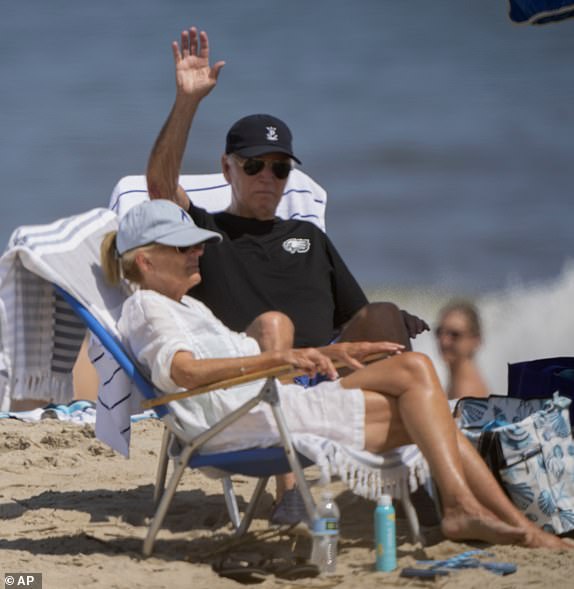 President Joe Biden, with first lady Jill Biden, waves as they sit at the beach in Rehoboth Beach, Del., Saturday, Aug. 31, 2024. (AP Photo/Manuel Balce Ceneta)