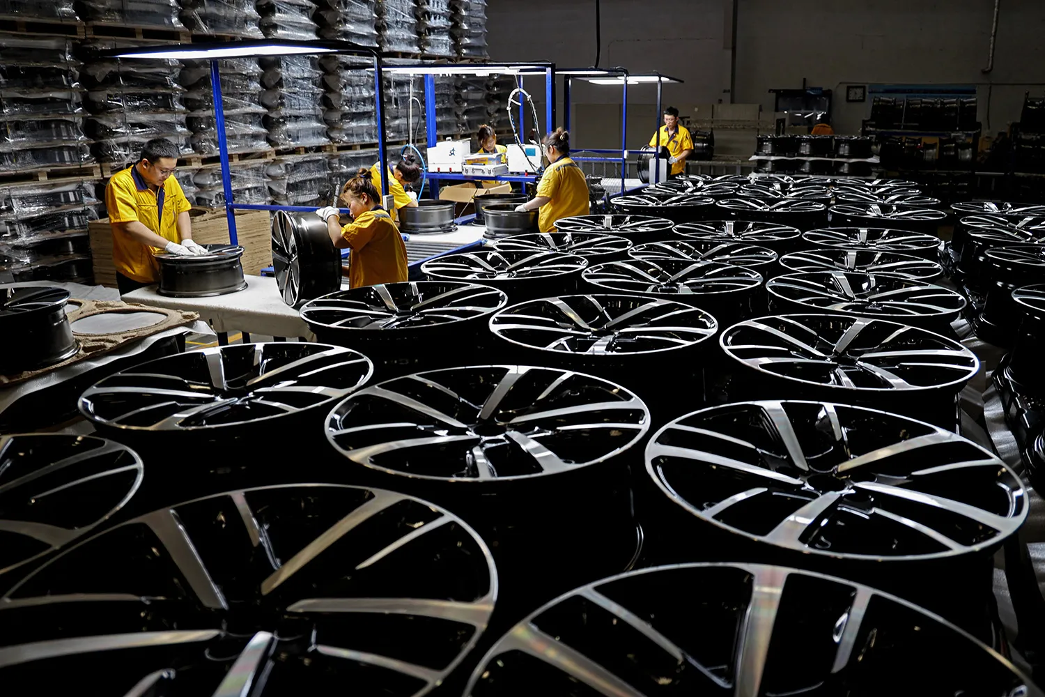 Employees work on a car wheel rim production line at a factory in Binzhou, China.