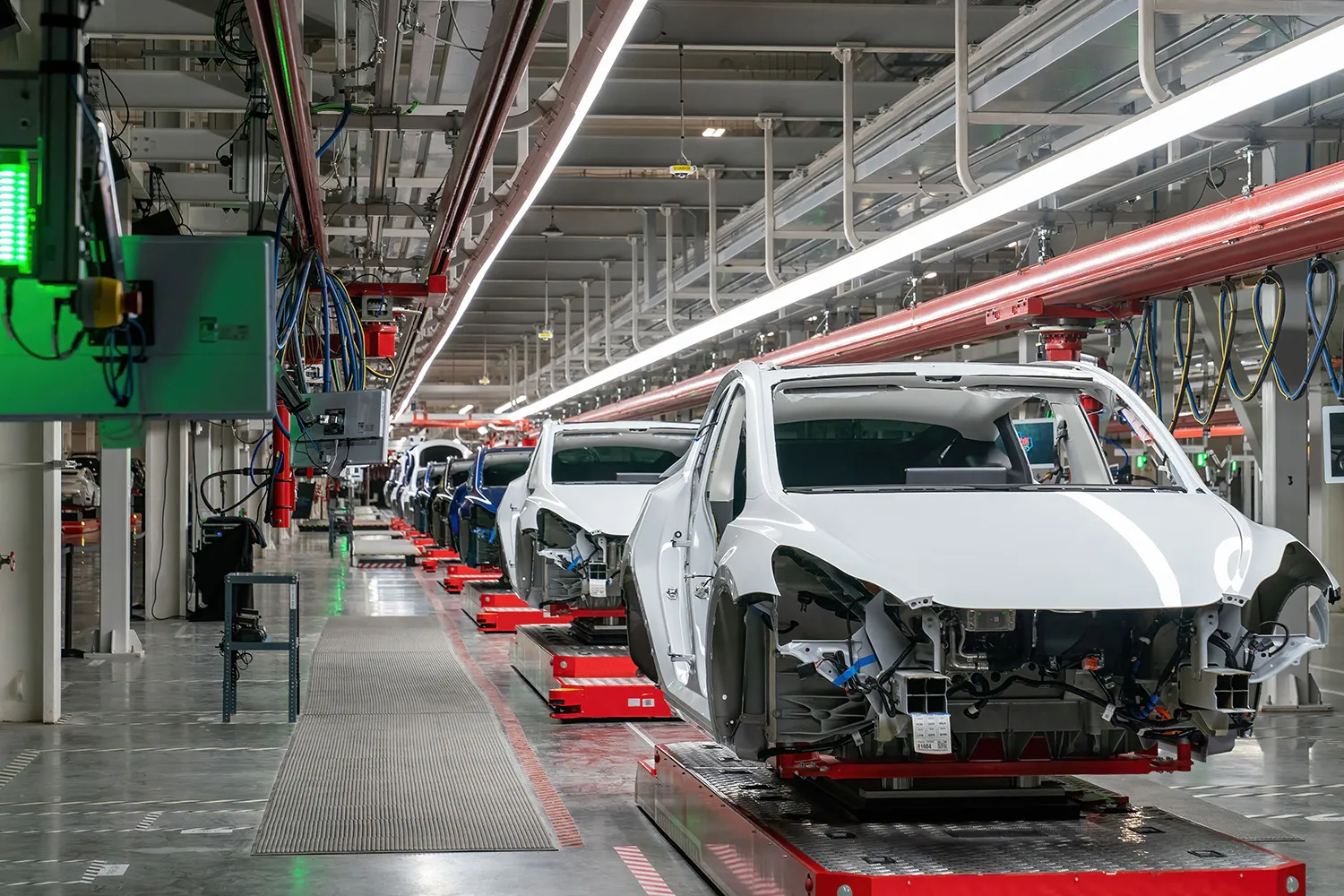 Car shells move through an assembly line at the Tesla Giga Texas manufacturing facility in Austin, Texas.