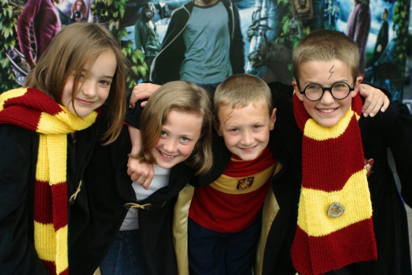 Wearing Hogwarts scarves, four children are ready for the Harry Potter movie at Odeon Dundee. 