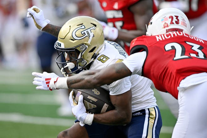 Sep 21, 2024; Louisville, Kentucky, USA; Georgia Tech Yellow Jackets wide receiver Malik Rutherford (8) runs the ball against Louisville Cardinals defensive back Tahveon Nicholson (23) during the first quarter at L&N Federal Credit Union Stadium. Mandatory Credit: Jamie Rhodes-Imagn Images