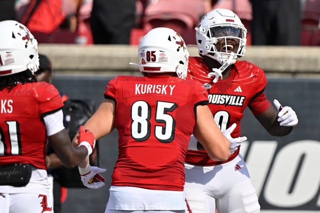 Sep 21, 2024; Louisville, Kentucky, USA; Louisville Cardinals wide receiver Chris Bell (0) celebrates a touchdown with tight end Nate Kurisky (85) during the first half against the Georgia Tech Yellow Jackets at L&N Federal Credit Union Stadium. Mandatory Credit: Jamie Rhodes-Imagn Images