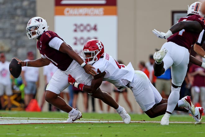 Sep 21, 2024; Blacksburg, Virginia, USA; Virginia Tech Hokies quarterback Kyron Drones (1) is pressed by Rutgers Scarlet Knights defensive back Desmond Igbinosun (4) during the second quarter at Lane Stadium. Mandatory Credit: Peter Casey-Imagn Images