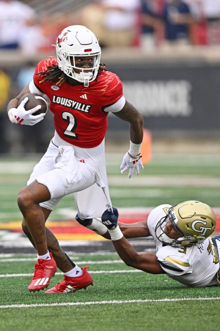 Sep 21, 2024; Louisville, Kentucky, USA; Louisville Cardinals wide receiver Jadon Thompson (2) tries to break free from the tackle of Georgia Tech Yellow Jackets defensive back Ahmari Harvey (3) during the second half at L&N Federal Credit Union Stadium. Mandatory Credit: Jamie Rhodes-Imagn Images