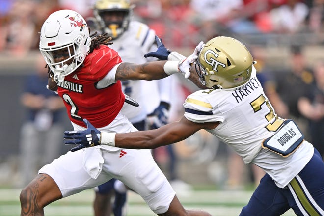 Sep 21, 2024; Louisville, Kentucky, USA; Louisville Cardinals wide receiver Jadon Thompson (2) runs the ball against Georgia Tech Yellow Jackets defensive back Ahmari Harvey (3) during the second half at L&N Federal Credit Union Stadium. Louisville defeated Georgia Tech 31-19. Mandatory Credit: Jamie Rhodes-Imagn Images