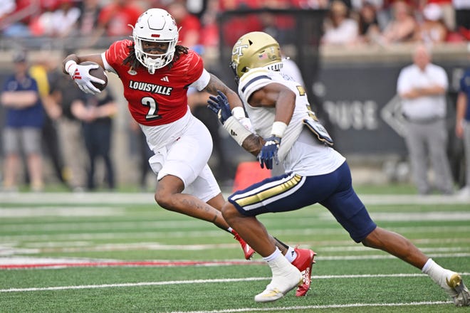 Sep 21, 2024; Louisville, Kentucky, USA; Louisville Cardinals wide receiver Jadon Thompson (2) runs the ball against Georgia Tech Yellow Jackets defensive back Ahmari Harvey (3) during the second half at L&N Federal Credit Union Stadium. Louisville defeated Georgia Tech 31-19. Mandatory Credit: Jamie Rhodes-Imagn Images