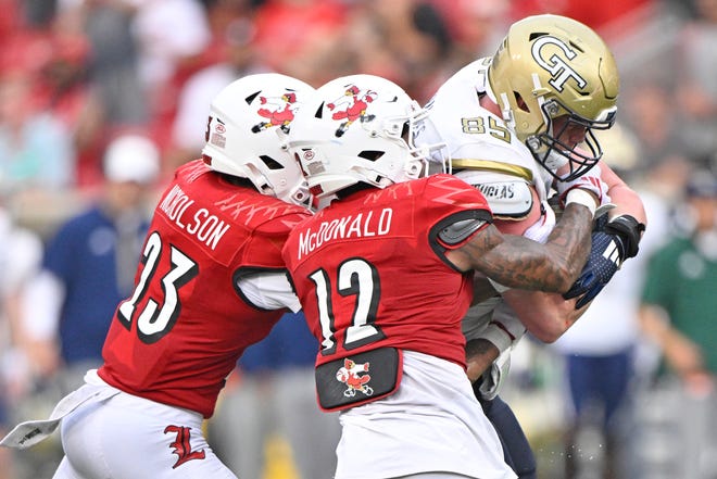 Sep 21, 2024; Louisville, Kentucky, USA; Georgia Tech Yellow Jackets tight end Jackson Hawes (85) tries to break free from the tackles of Louisville Cardinals defensive back Tamarion McDonald (12) and defensive back Tahveon Nicholson (23) during the second half at L&N Federal Credit Union Stadium. Mandatory Credit: Jamie Rhodes-Imagn Images