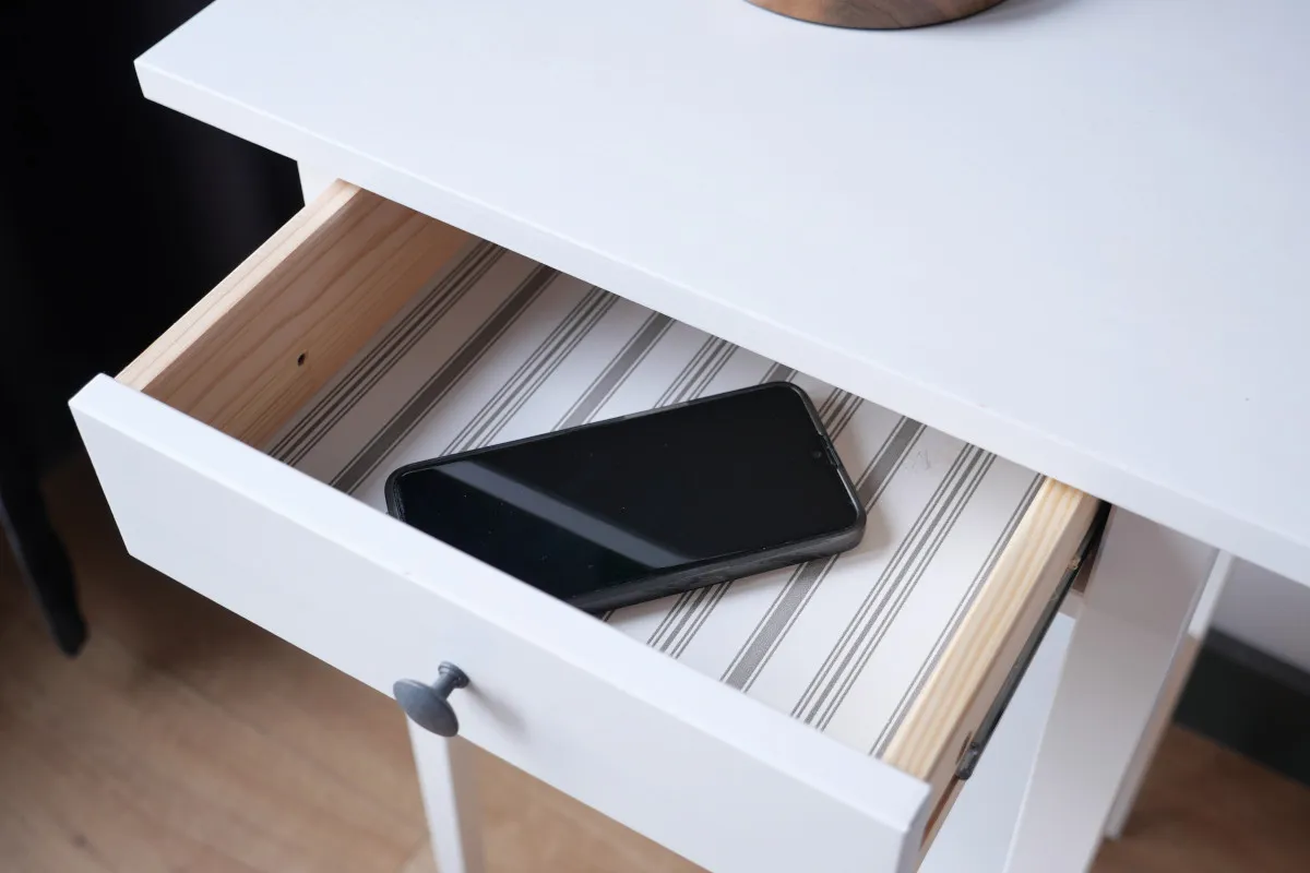 Photo of a mobile phone in a drawer.