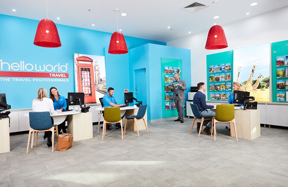 Interior of Helloworld retail store with agents and customers.