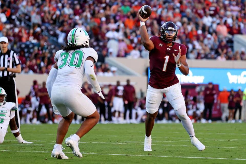 Sep 7, 2024; Blacksburg, Virginia, USA; Virginia Tech Hokies quarterback Kyron Drones (1) throws a pass against Marshall Thundering Herd linebacker Jaden Yates (30) during the second quarter at Lane Stadium.