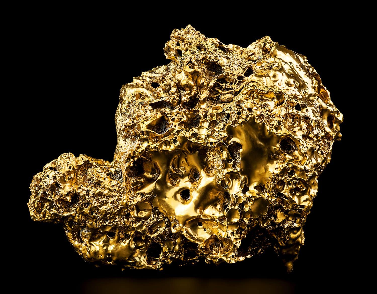 Pure gold from the mine on black background. Closeup of gold nugget. Finance and business concept.