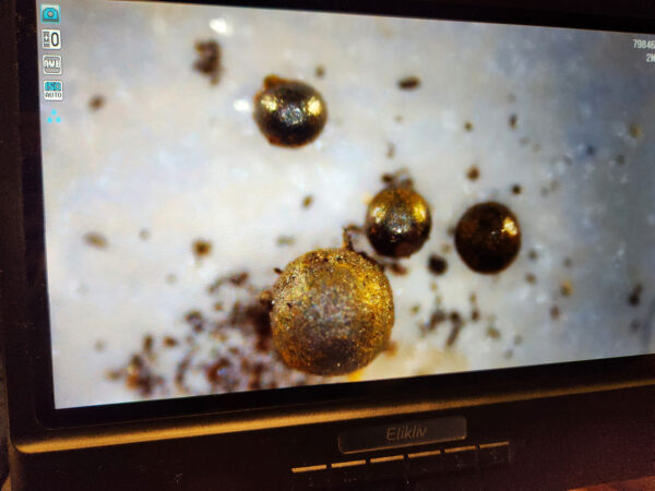 a photo of a laptop screen showing bronze metal spheres