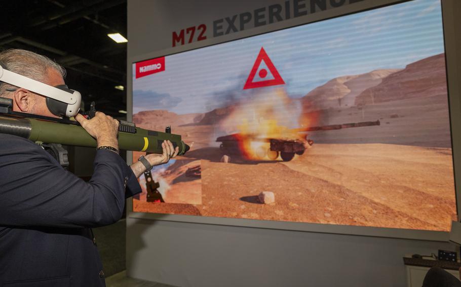 A visitor to the Nammo booth uses VR to target a tank with a rocket launcher