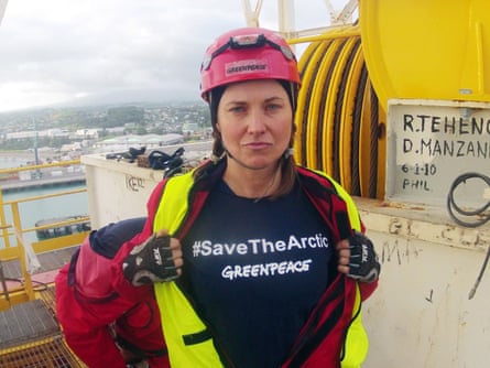 She wears a hard hat and a shirt saying Save the Arctic