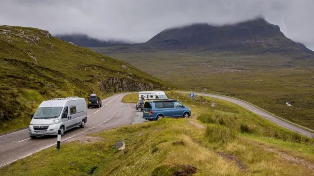 Getty Images Traffic on a road and parked in a parking area on the NC500 near Ullapool