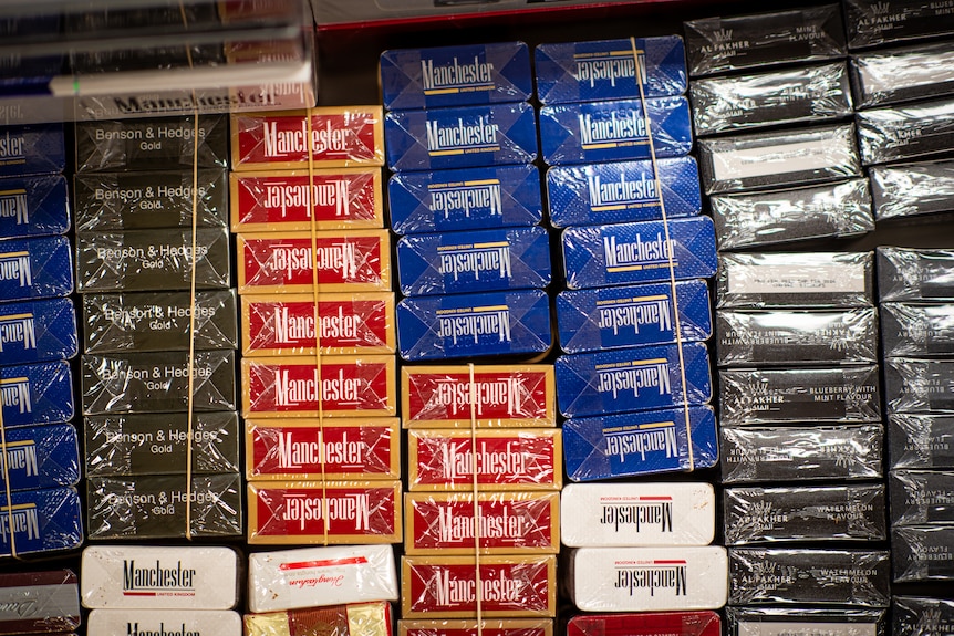 Stacks of cigarette packets in different brands and colours.