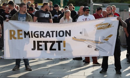 Far-right demonstrators hold a banner reading ‘remigration now’