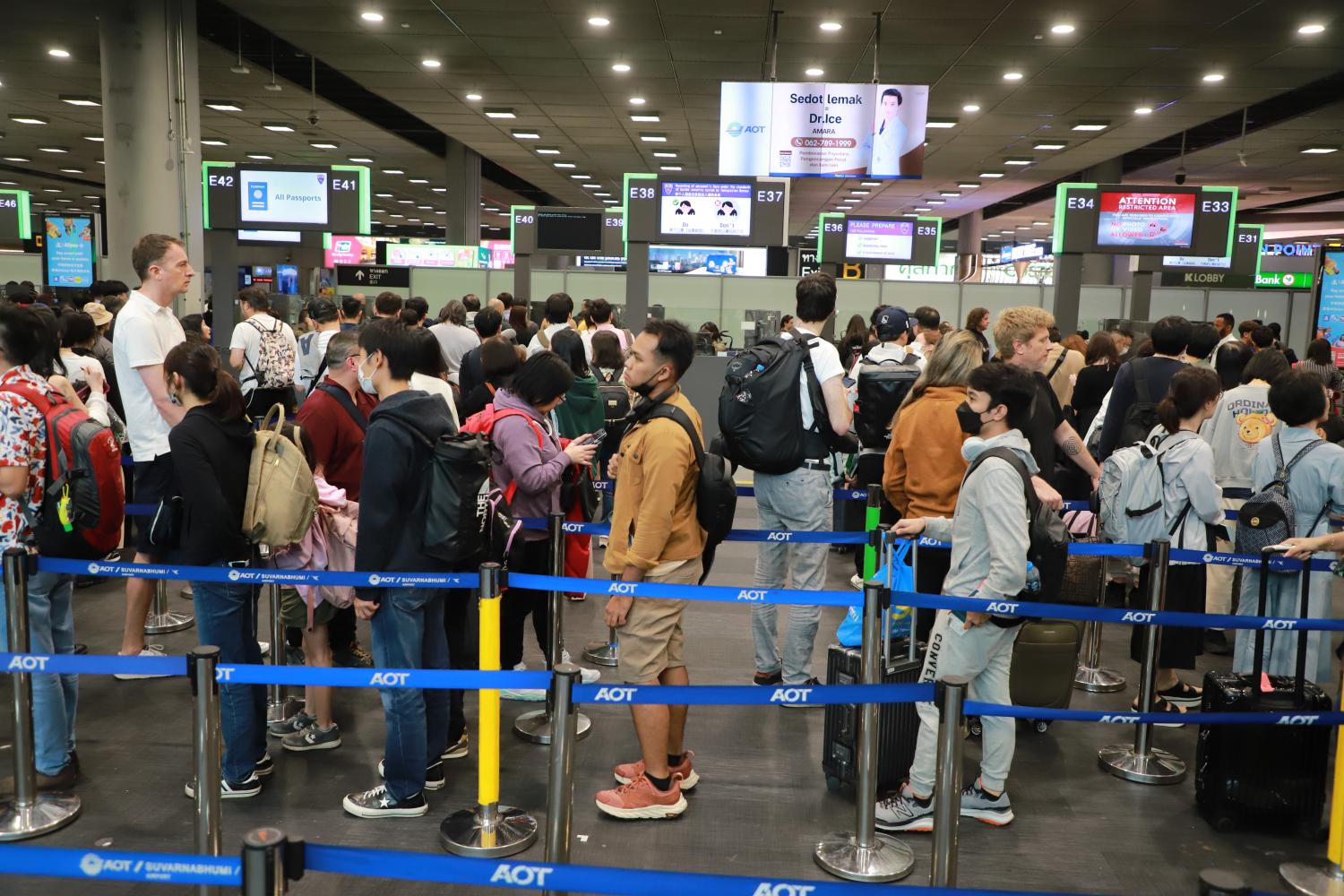 Arriving passengers queue for immigration counters at Suvarnabhumi airport. Somchai Poomlard