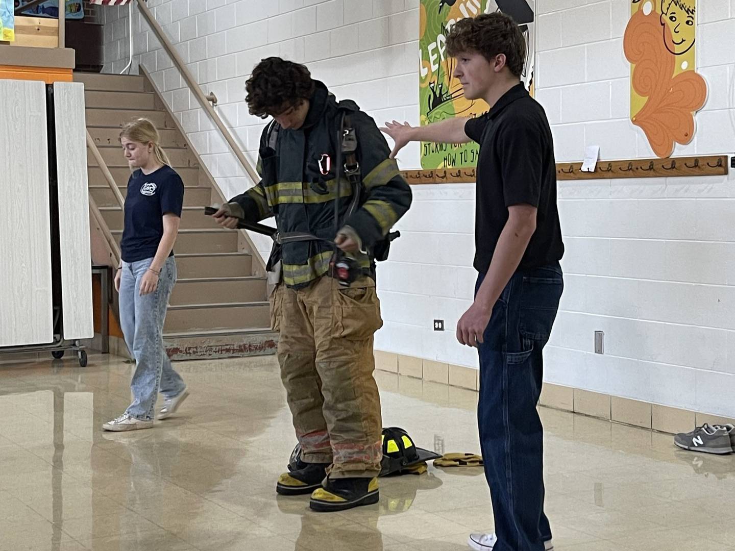 Caycee Brown, Owen Novinski and Brandon Legner explain how the firefighters put on their equipment.