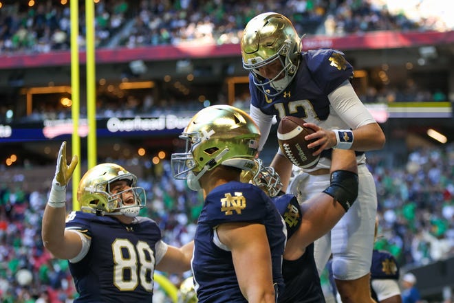 Oct 19, 2024; Atlanta, Georgia, USA; Notre Dame Fighting Irish quarterback Riley Leonard (13) celebrates with teammates after a touchdown against the Georgia Tech Yellow Jackets in the second quarter at Mercedes-Benz Stadium. Mandatory Credit: Brett Davis-Imagn Images