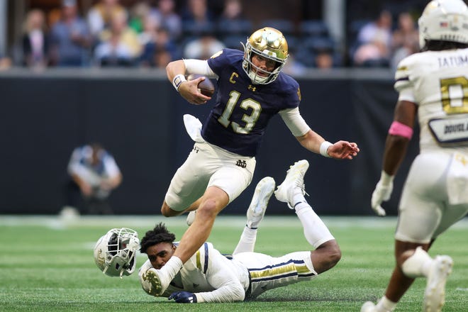 Oct 19, 2024; Atlanta, Georgia, USA; Notre Dame Fighting Irish quarterback Riley Leonard (13) scrambles past Georgia Tech Yellow Jackets defensive back Clayton Powell-Lee (5) in the fourth quarter at Mercedes-Benz Stadium. Mandatory Credit: Brett Davis-Imagn Images