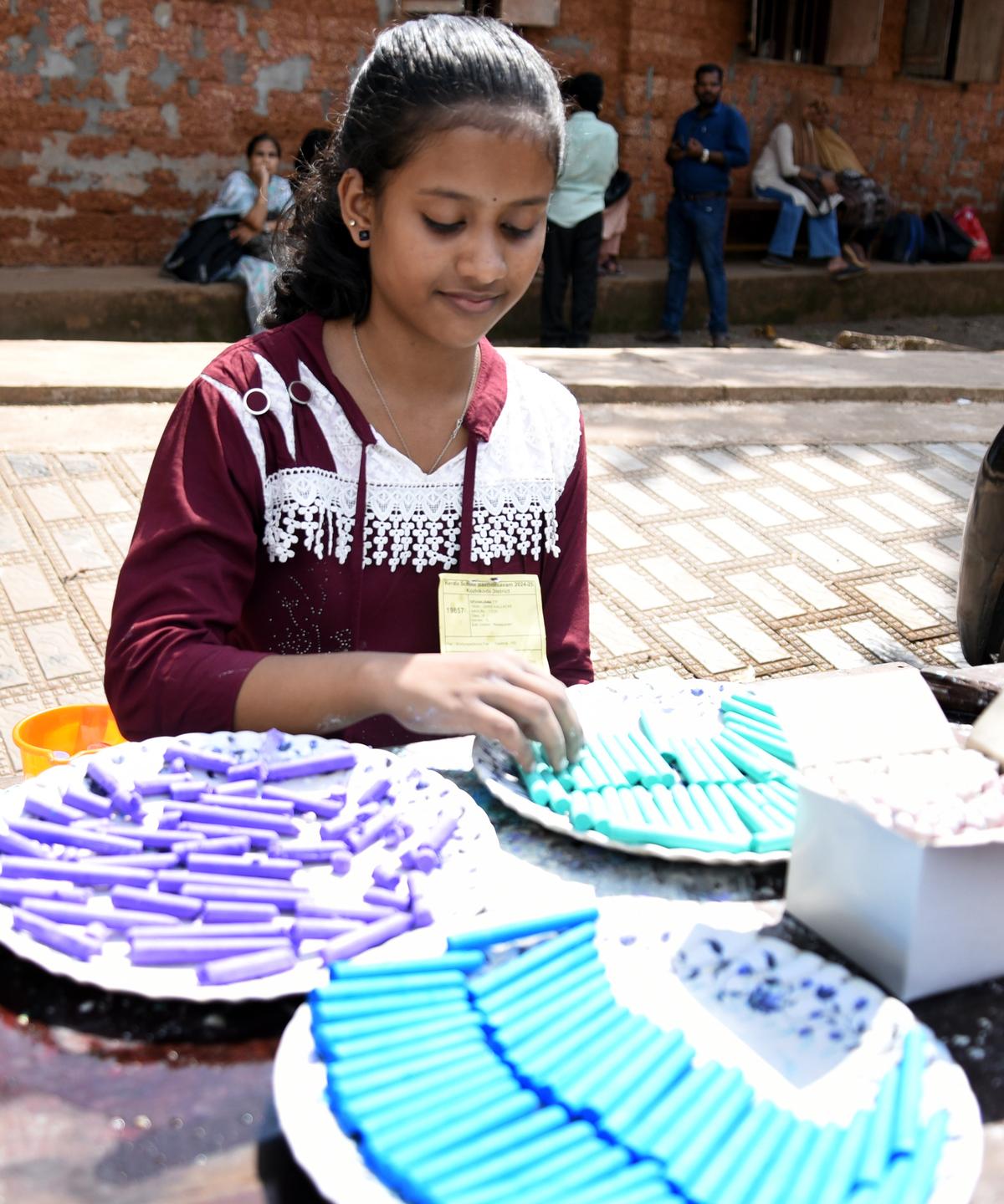 T.T. Devanjana, student of GHSS, Kallachi, displaying the colourful chalks after the the chalk-making contest.