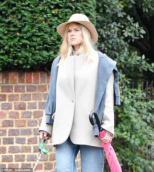 British Actress Alice Eve seen out in the inclement weather of the capital as she takes her pet pooch out for a walk in London