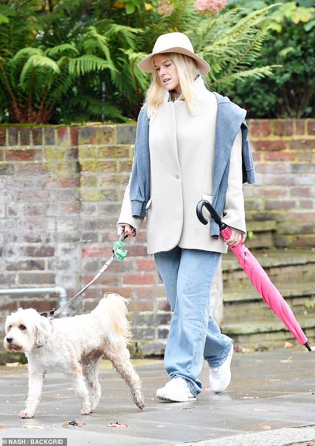 Alice Eve looks a little deep in thought out on a walk with her dog