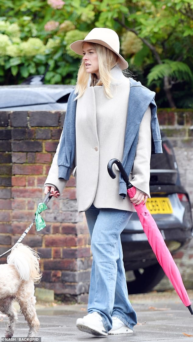 She was armed with a pink umbrella as protection against the inclement weather