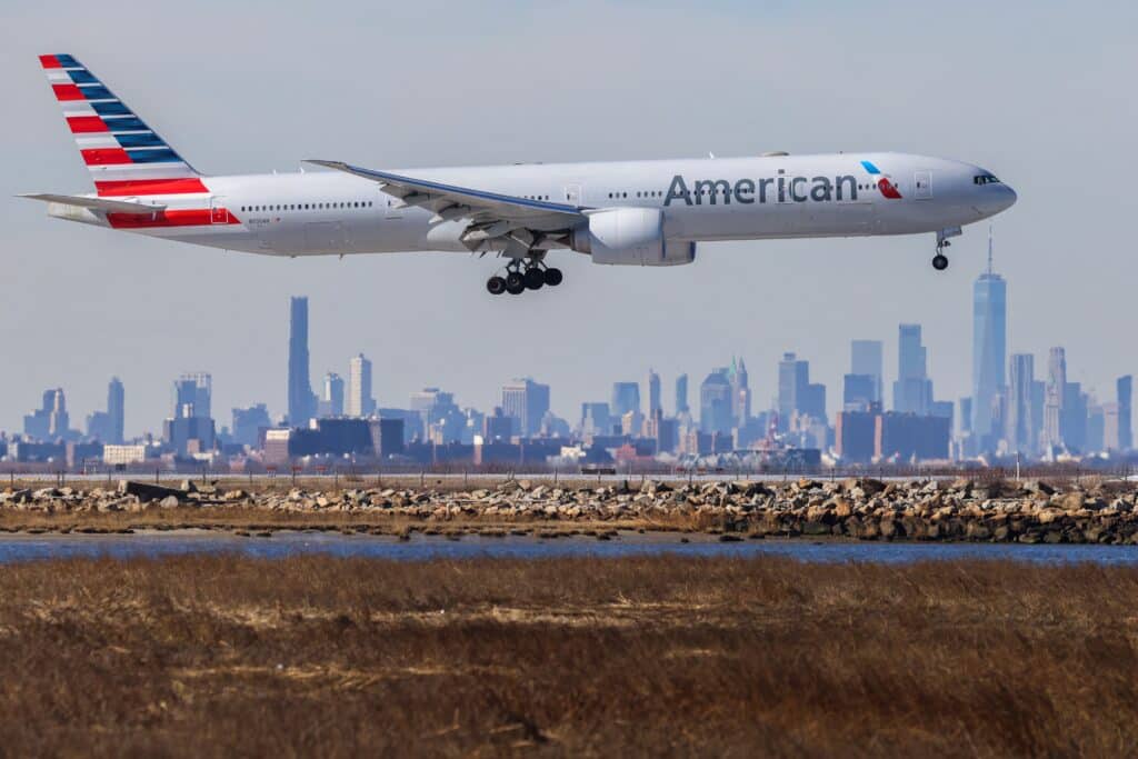 A Boeing 777 passengers aircraft of American Airlines arrives from Miami at JFK International Airport in New York as the Manhattan skyline looms in the background on February 7, 2024. (Photo by Charly TRIBALLEAU / AFP)