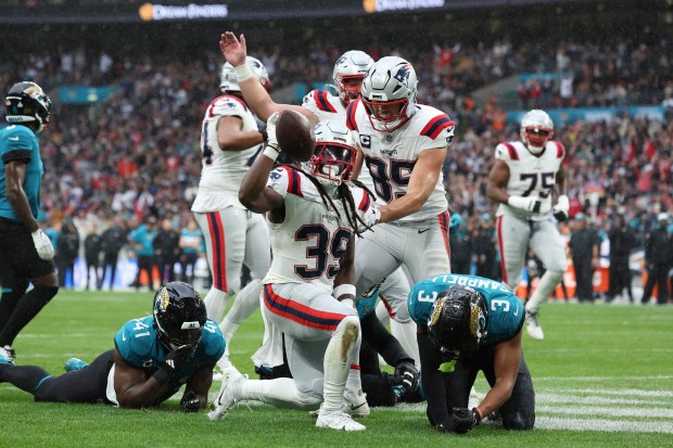 New England Patriots running back JaMycal Hasty (39) holds up the ball after his 16-yard reception for a touchdown during the first half of an NFL football game against the Jacksonville Jaguars, Sunday, Oct. 20, 2024, in London. (AP Photo/Ian Walton)