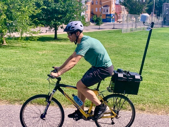 Ben Zaitchik, a heat specialist and one of the leads on the Hopkins climate project, captures spatial temperature variations across Baltimore neighborhoods using a bike with a pole-mounted temperature device. Credit: Aman Azhar/Inside Climate News