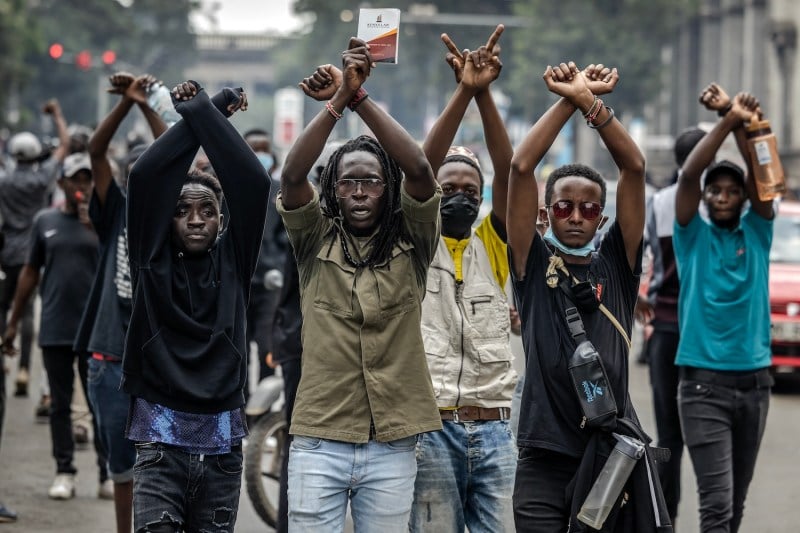 People hold up their arms in protest on the street.