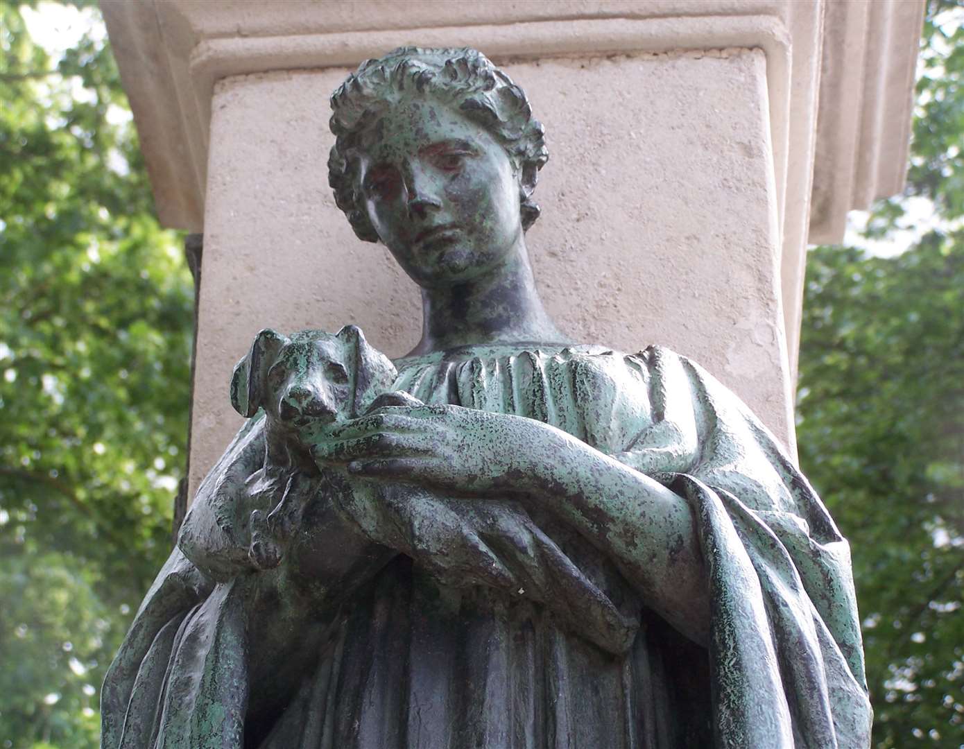 This is part of the monument to the novelist Ouida Louise De La Ramee - this is one of two bronze figures, Sympathy, embracing a dog, while the other one called Courage holds a sword. It was unveiled in 1910 at the Spread Eagle junction by Lady Evelyn Guinness and local dignitaries