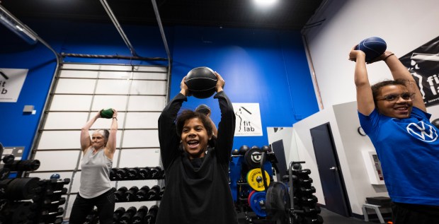 Girls and women lift weights above their heads