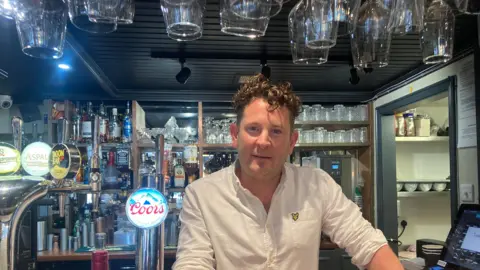 Business owner Matthew Ronowitz behind the bar in his restaurant in Tenby. 