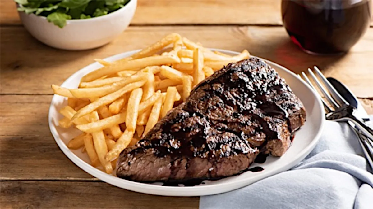 Photo of steak and chips on a plate.