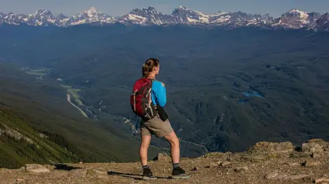 Getty Images A woman looking at the Rocky Mountains in Canada