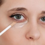 woman applying under-eye concealer