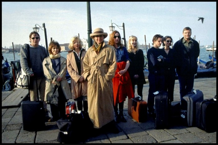 Cast members of ‘Italian for Beginners’ standing with suitcases in front of the Lagoon