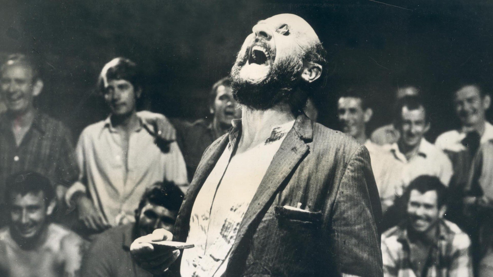 Donald Pleasence laughs with coins over his eyes in the film 