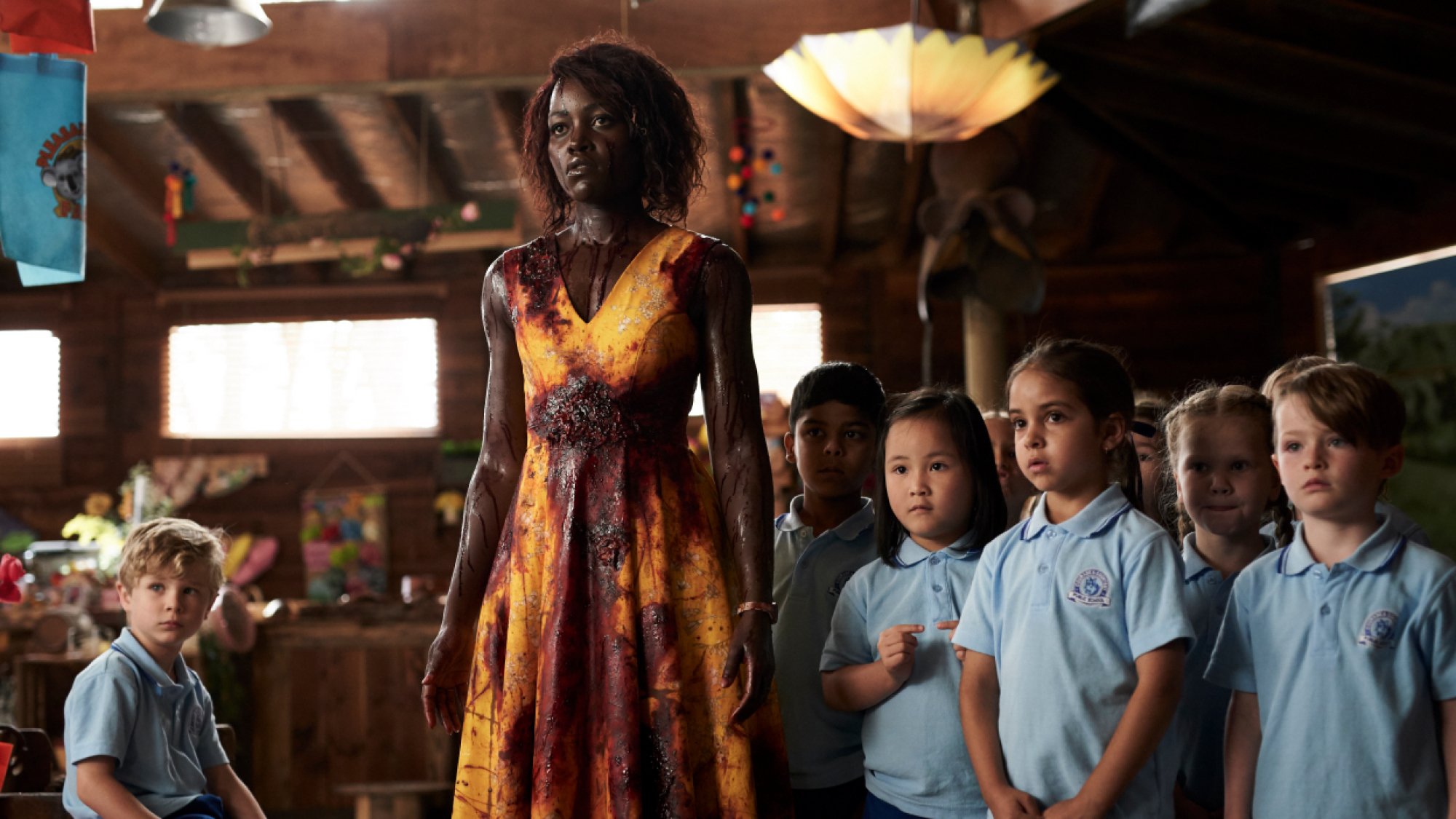 Lupita Nyong'o stands with a class of kindergarteners, covered in blood, in the film 