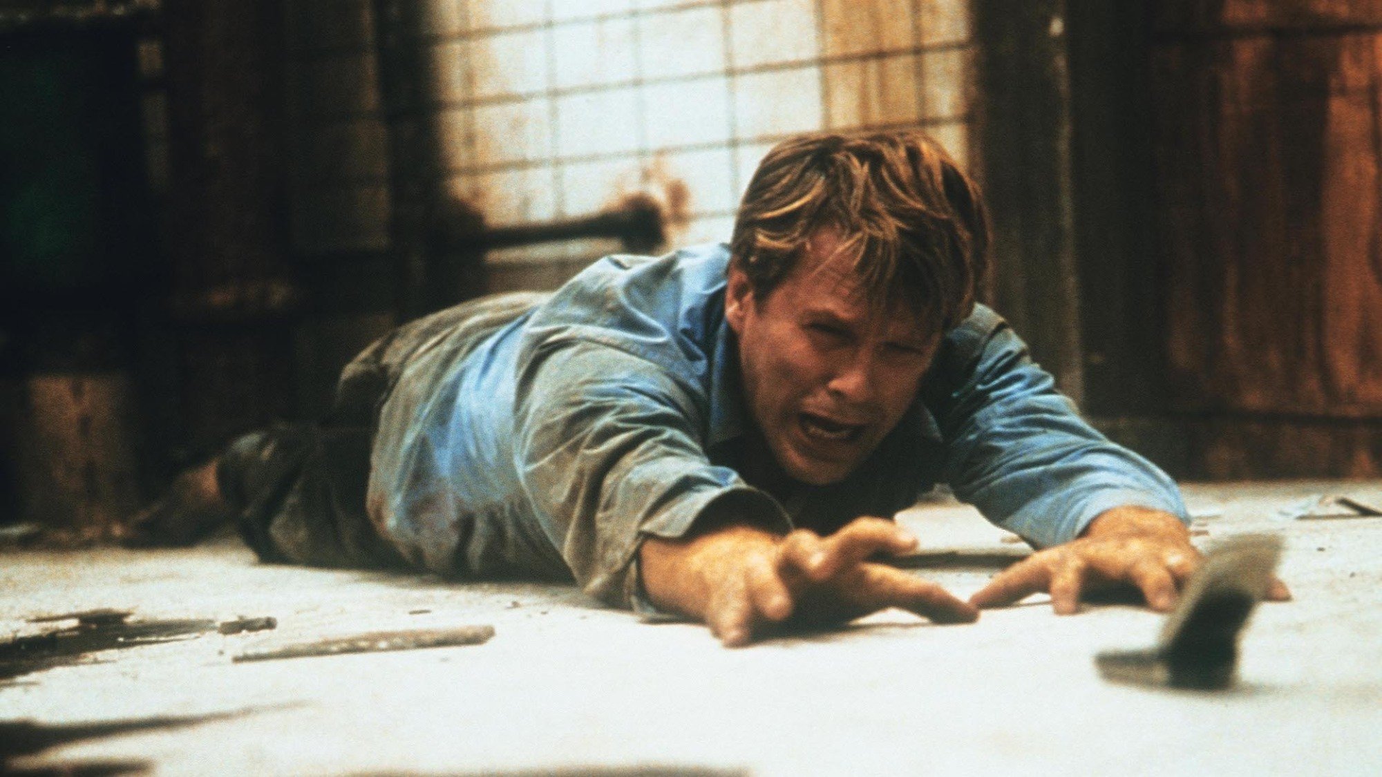 Cary Elwes looks in despair in a dilapidated bathroom in the film 