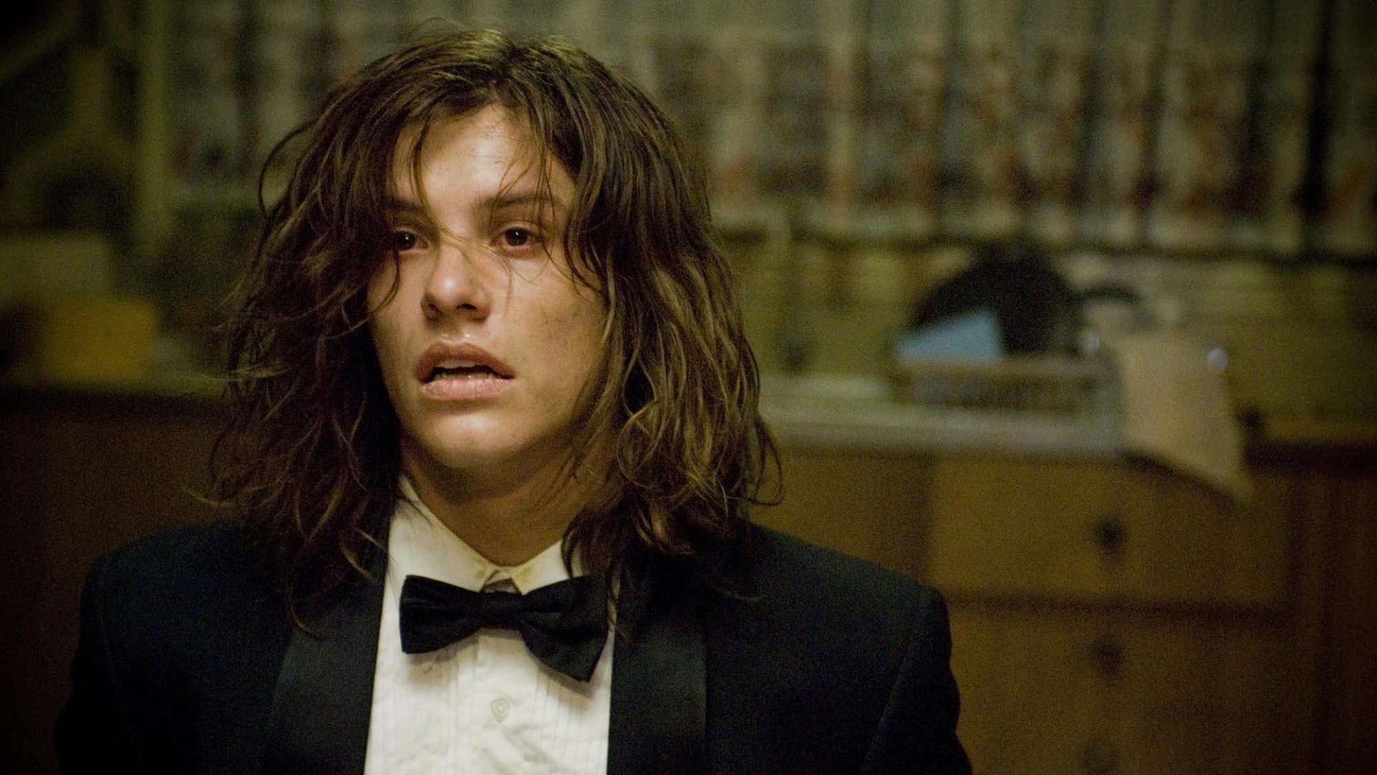 Xavier Samuel sits in a kitchen chair in a suit, looking despondent, in the film 