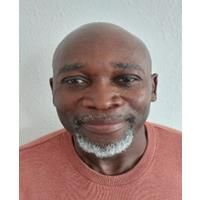 Headshot of Wayne Wright. Wayne is wearing an organe jumper and is smiling at the camera.