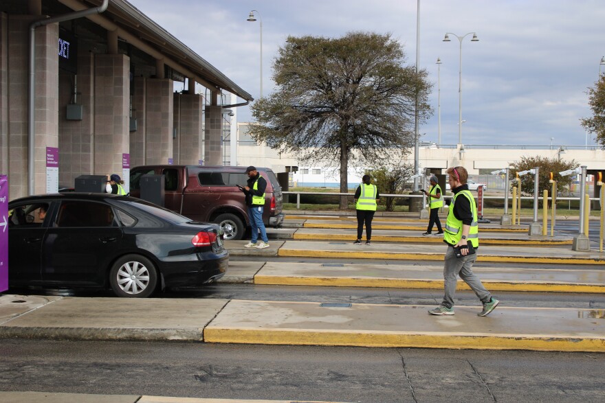 Metropolis staff helping travelers exit the garage through the gates now operated by Metropolis.