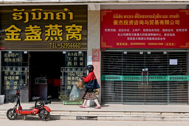 woman walking in front Chinese stores in Laos' capital Vientiane