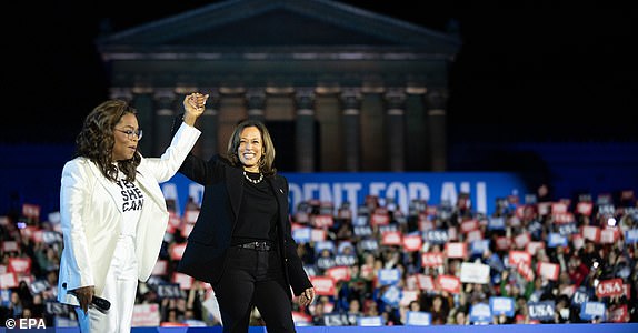 epa11701941 Oprah Winfrey (L) speaks to rally attendees, encouraging them to support US Vice President and Democratic presidential nominee Kamala Harris (R), in Philadelphia, Pennsylvania, USA, 04 November 2024. US Vice President and Democratic Presidential Nominee Kamala Harris is holding an election eve concert and rally in Philadelphia. Election polls show that the presidential race between Harris and Republican nominee former President Donald Trump is extremely close.  EPA/DAVID MUSE