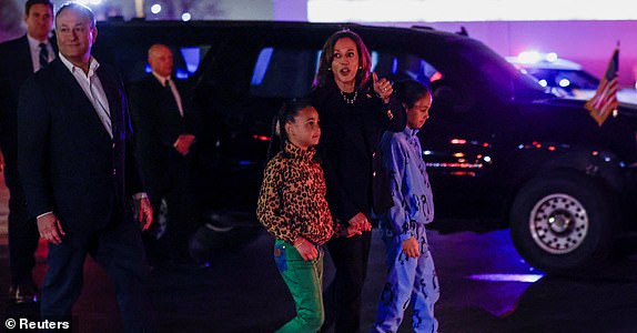 Democratic presidential nominee U.S. Vice President Kamala Harris gestures as she walks with Second Gentlemen Doug Emhoff and her great-nieces Amara and Leela to board Air Force Two at Philadelphia International Airport, Pennsylvania, U.S., November 5, 2024. REUTERS/Evelyn Hockstein REFILE - QUALITY REPEAT