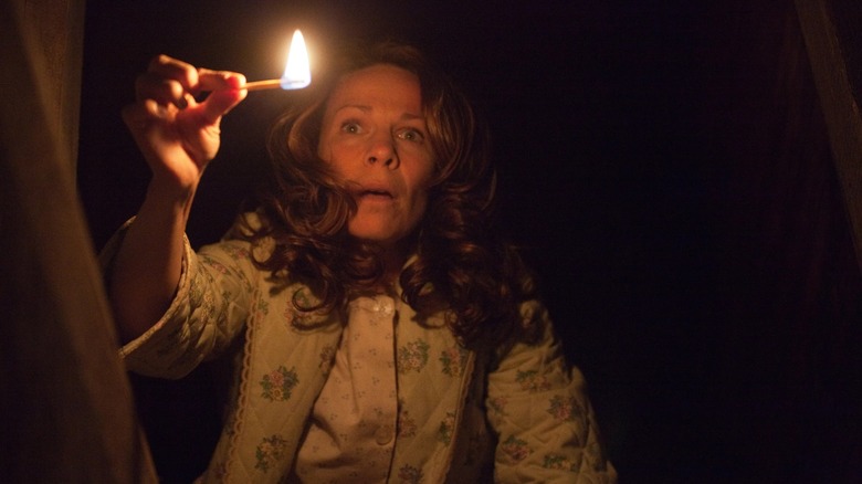 Lili Taylore as Carolyn Perron holding a lit match in The Conjuring